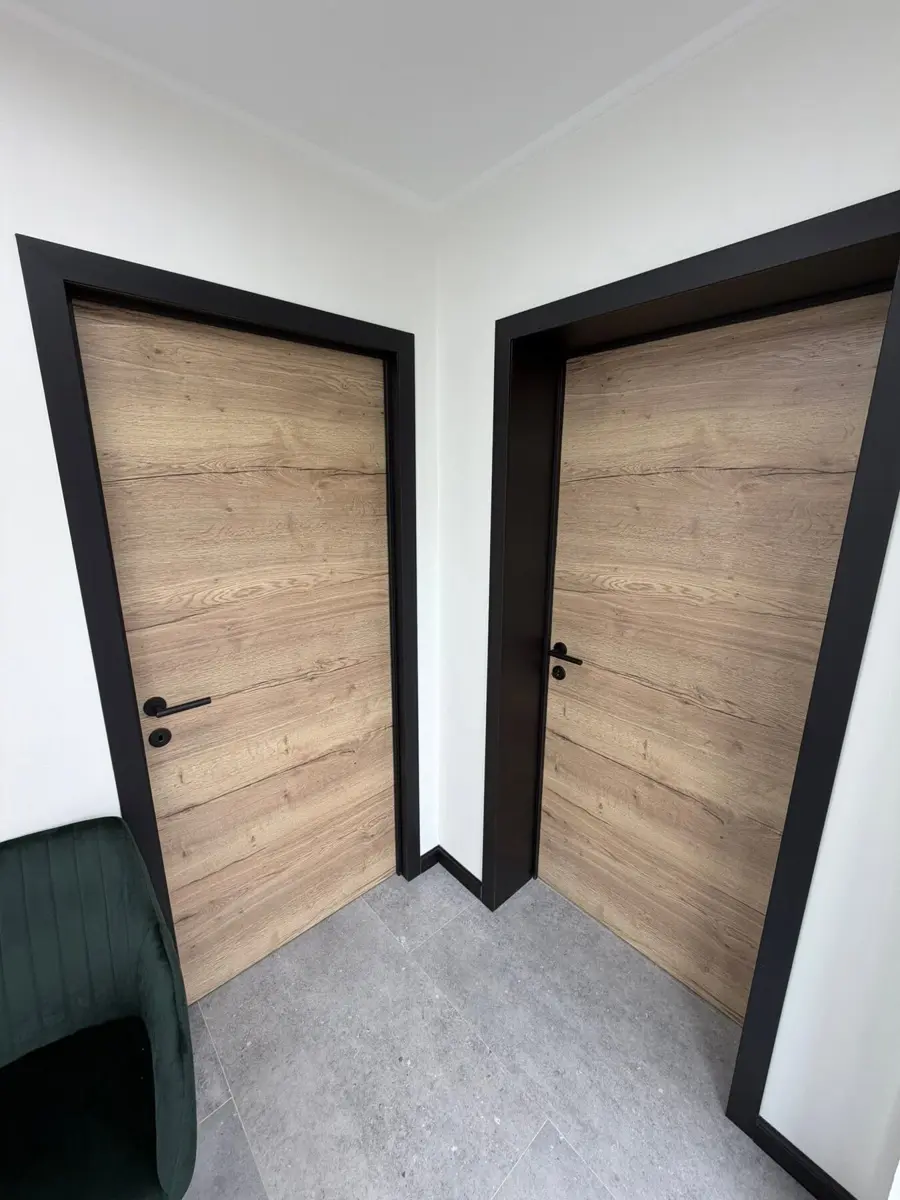 Deux portes intérieures teinte bois encadrées de chambranles noirs