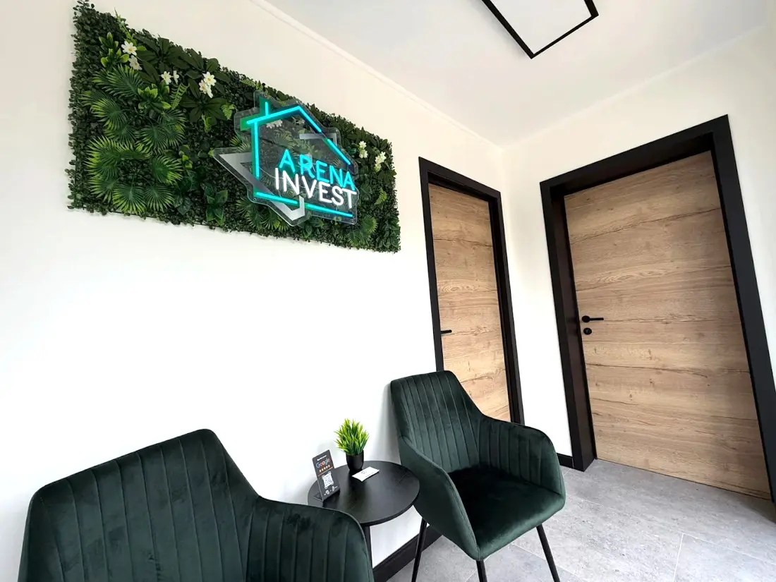 Bureau d’Arena Invest à Courcelles, avec le logo de l’entreprise au mur